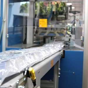 Fertig eingeschweißte und mit Label versehene Beipacks / Zubehörbeutel auf dem Weg zum Verpacken