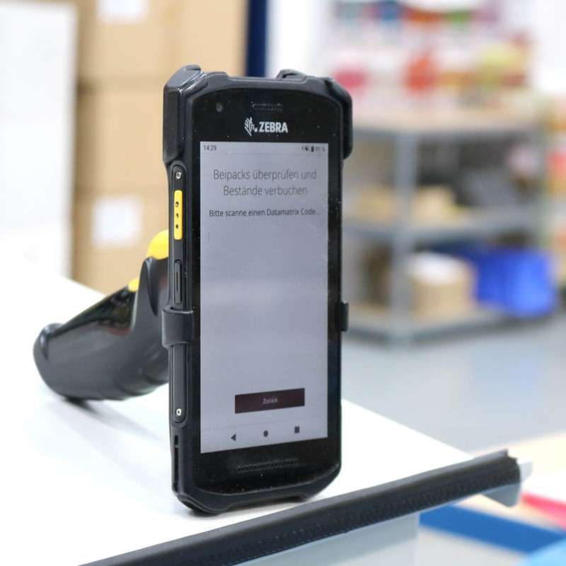 Mit einem Handscanner prüfen wir die fertigen Beipacks / Zubehörbeutel, ob sie auch in der korrekten Reihenfolge (Sequenz) sind
