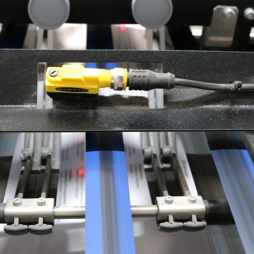 Ein Sensor in einer Digitaldruck-Maschine, die den Papierlauf überwacht